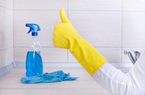 Cleaner using safe manual handling techniques during a cleaning task